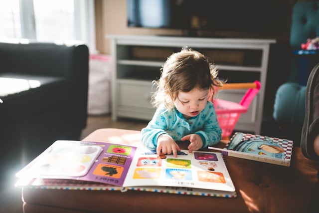 A young child happily exploring an activity book at home